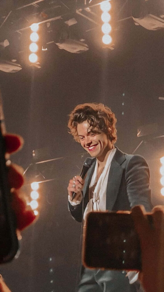 Sizzling Stage Swagger: A Captivating Snapshot of Harry Styles Rocking the Spotlight Wallpaper