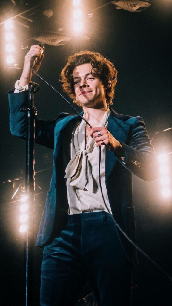 Harry Styles On Stage: Stylish Performance with Vibrant Concert Lights Wallpaper