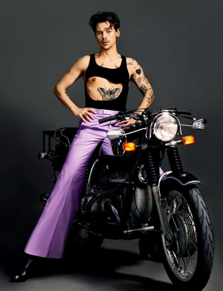 Edgy Harry Styles Wallpaper: Confident Pose on Motorcycle