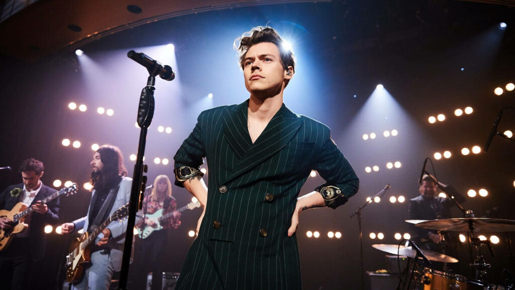 Harry Styles and his Melodic Band: Captivating Onstage Performance Wallpaper