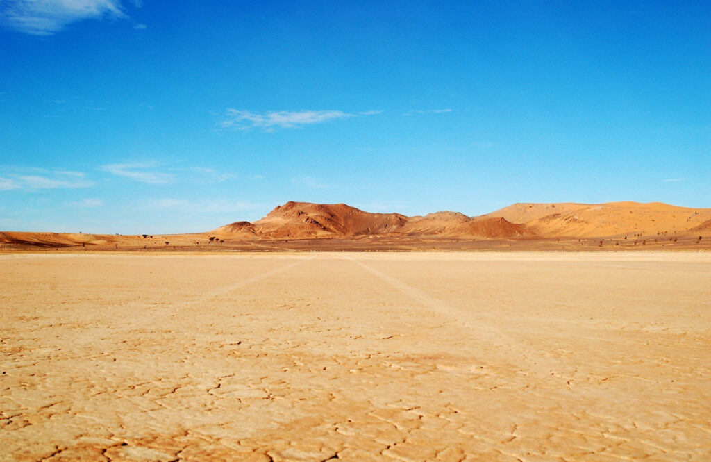 Barren Wasteland: Scorching Desert Tones meet Clear Azure Skies Wallpaper