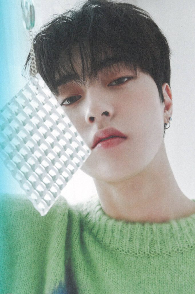TREASURE Haruto in lime-green sweater holding textured glass panel vibrant K-pop portrait wallpaper