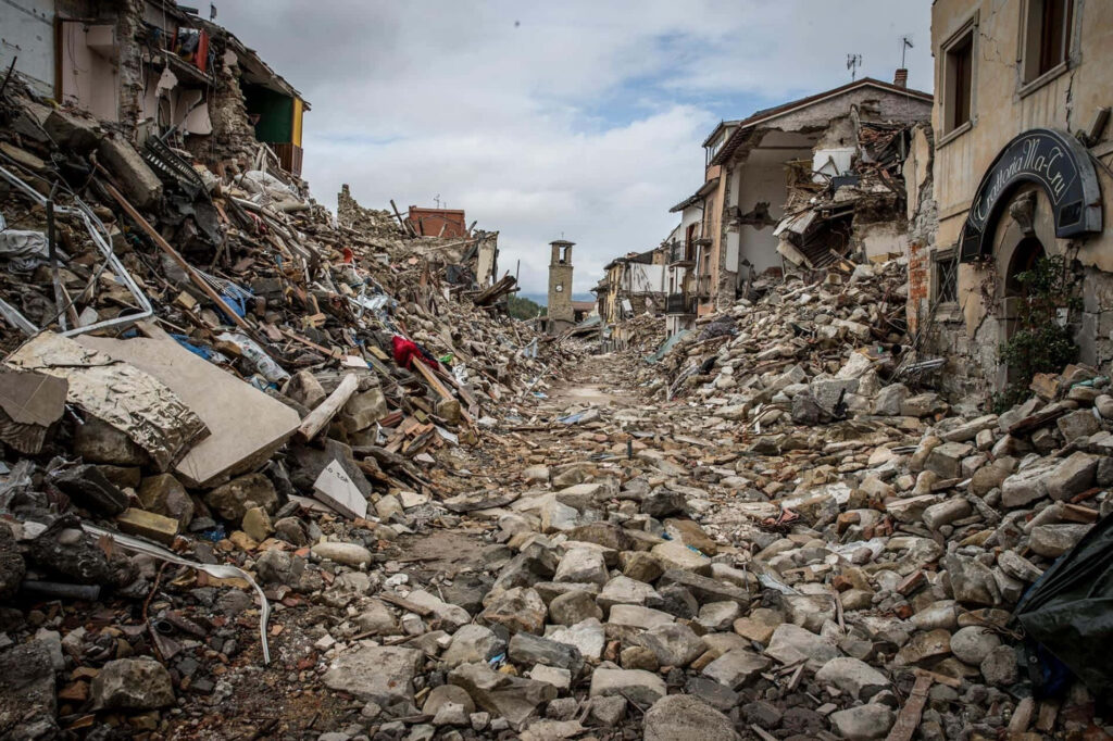 Earthquake destruction wallpaper showing collapsed buildings debris on empty street in muted earth tones