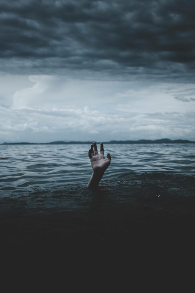 Haunting Wallpaper: Struggling Hand Emerges from Dark Waters
