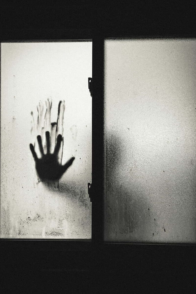 Chilling Frosted Window Wallpaper: Haunting Shadowy Mystery Background