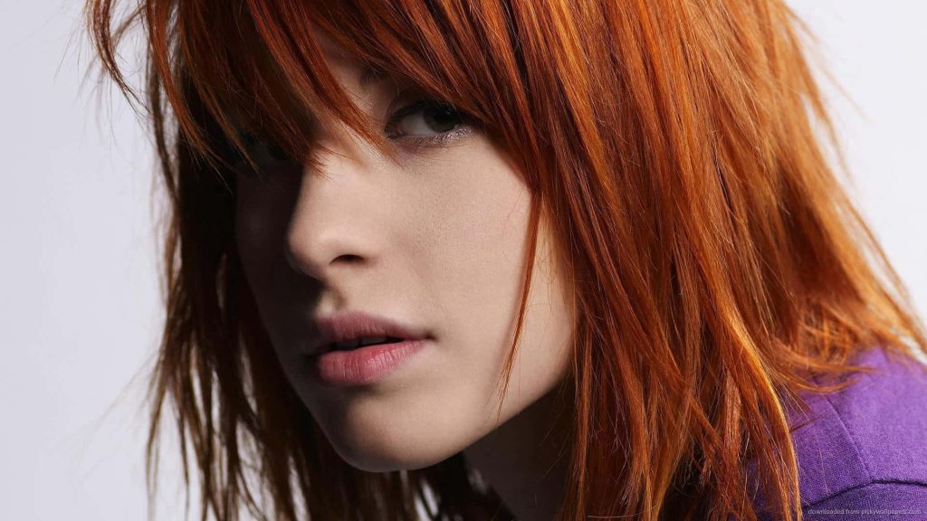 Close-up portrait of Hayley Williams with vibrant red hair and intense focused gaze wallpaper