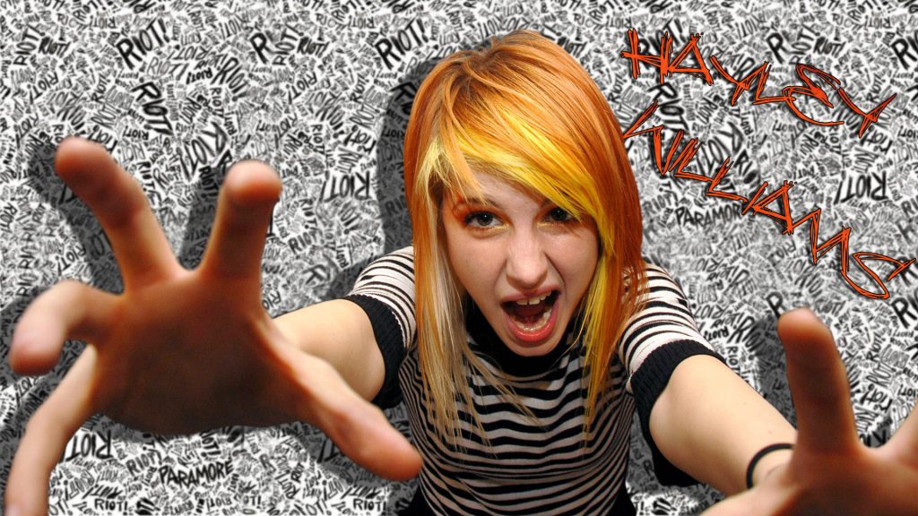 Hayley Williams of Paramore iconic pose fiery orange hair striped top Riot logo wallpaper background