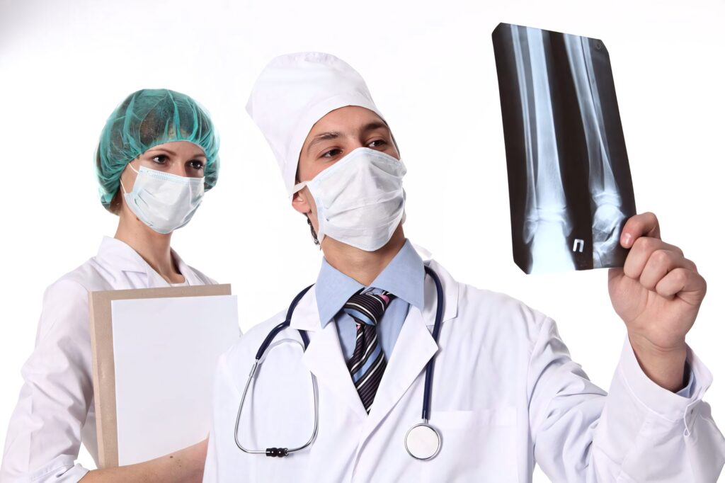 Two doctors in white coats examining leg bone Xray showing medical expertise and patient care Wallpaper