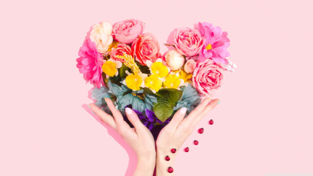 Heart-Shaped Bouquet of Colorful Roses on Soft Pink Background Wallpaper