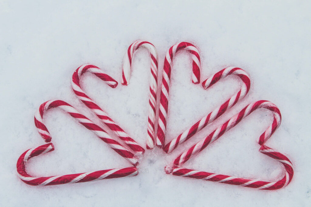 Festive Candy Cane Hearts Wallpaper on Snowy White Background