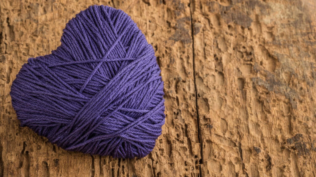 Rustic Purple Yarn Heart on Textured Wood - Artistic Wallpaper Background