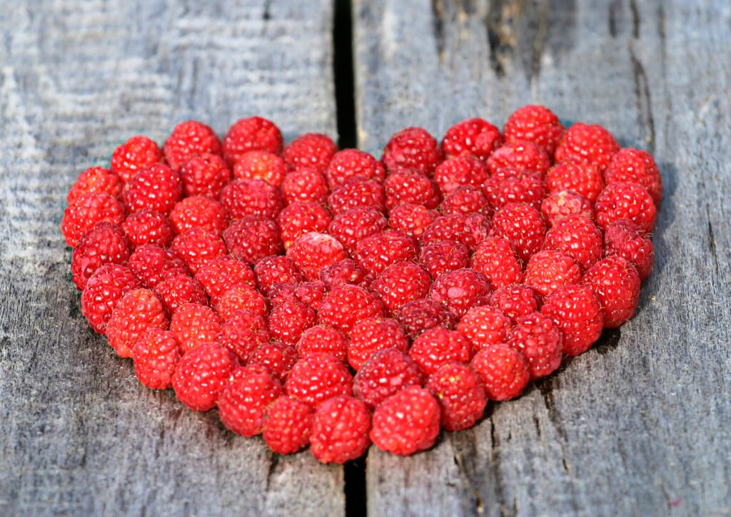 Vibrant Red Raspberries Heart on Rustic Wood - Charming Wallpaper