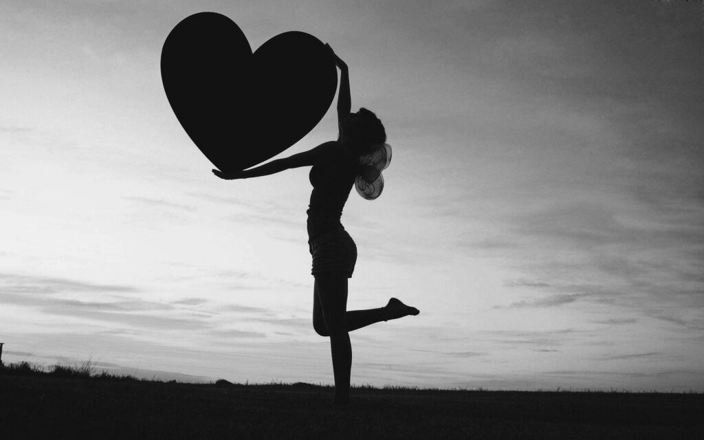 Silhouette Pose with Heart Against Dramatic Black-and-White Sky Wallpaper