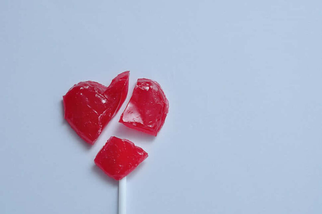 Broken Heart-Shaped Lollipop: Symbol of Heartbreak Wallpaper Background