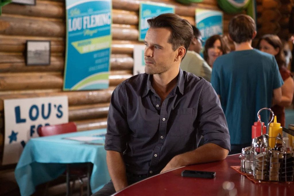 Graham Wardle as Ty Borden in Heartland diner with rustic log walls and campaign poster wallpaper