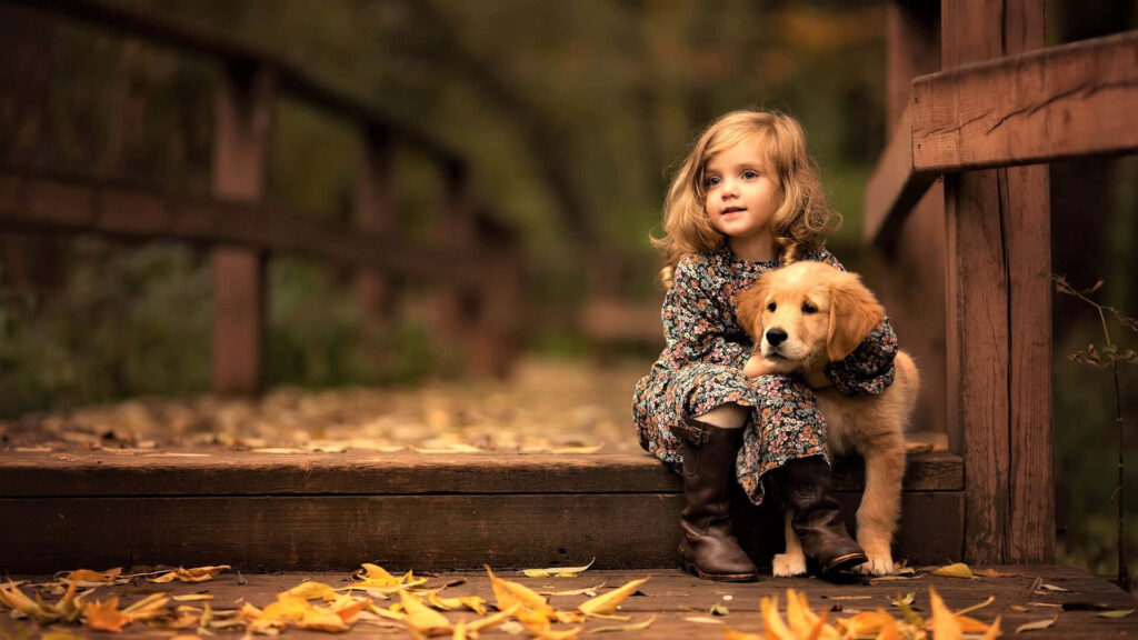 Heartwarming Autumn Scene: Girl & Golden Retriever on Wooden Bridge Wallpaper