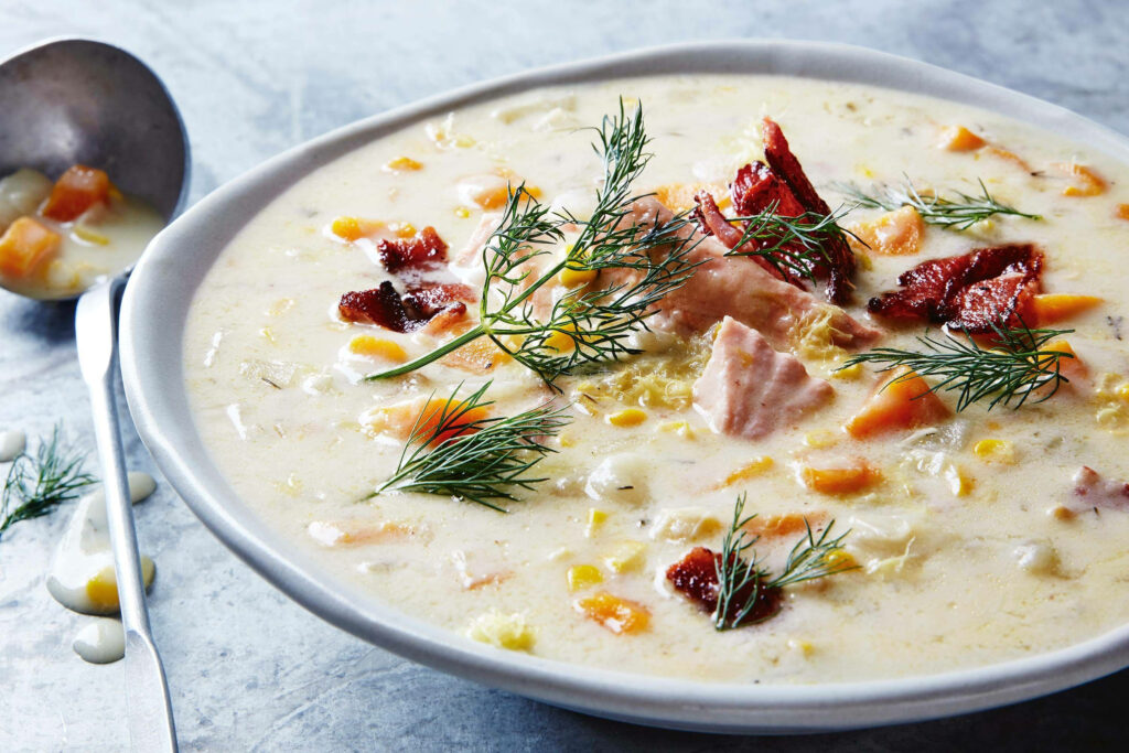 Creamy hearty bacon and salmon chowder with fresh dill and vegetables in warm natural light Wallpaper