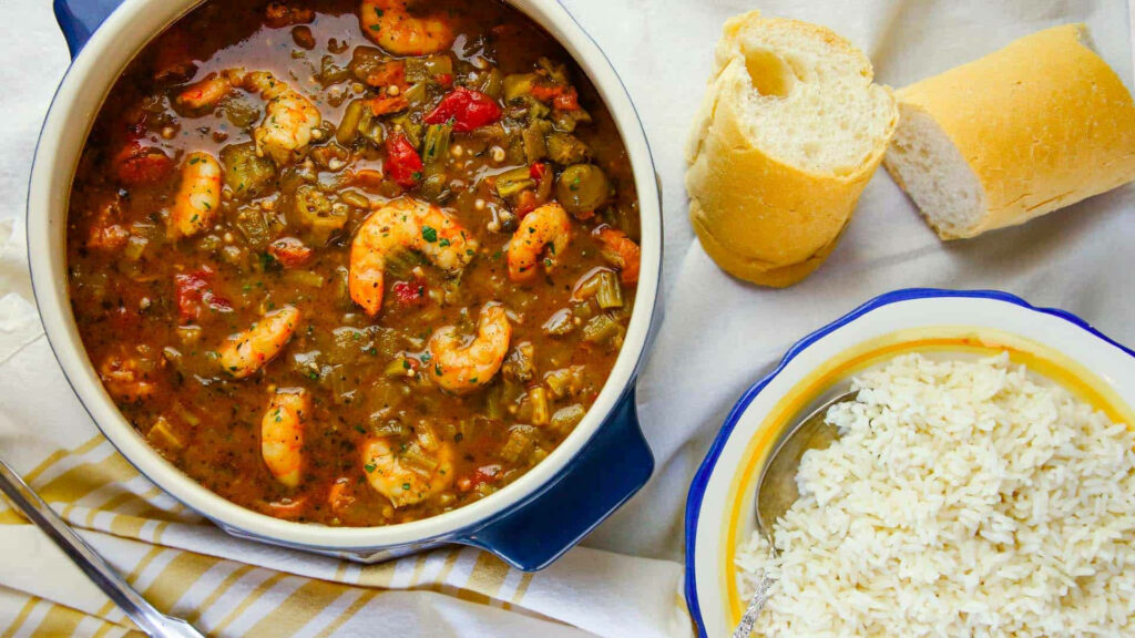 Hearty Creole shrimp gumbo with okra bell peppers and tomatoes served with rice and baguette Wallpaper