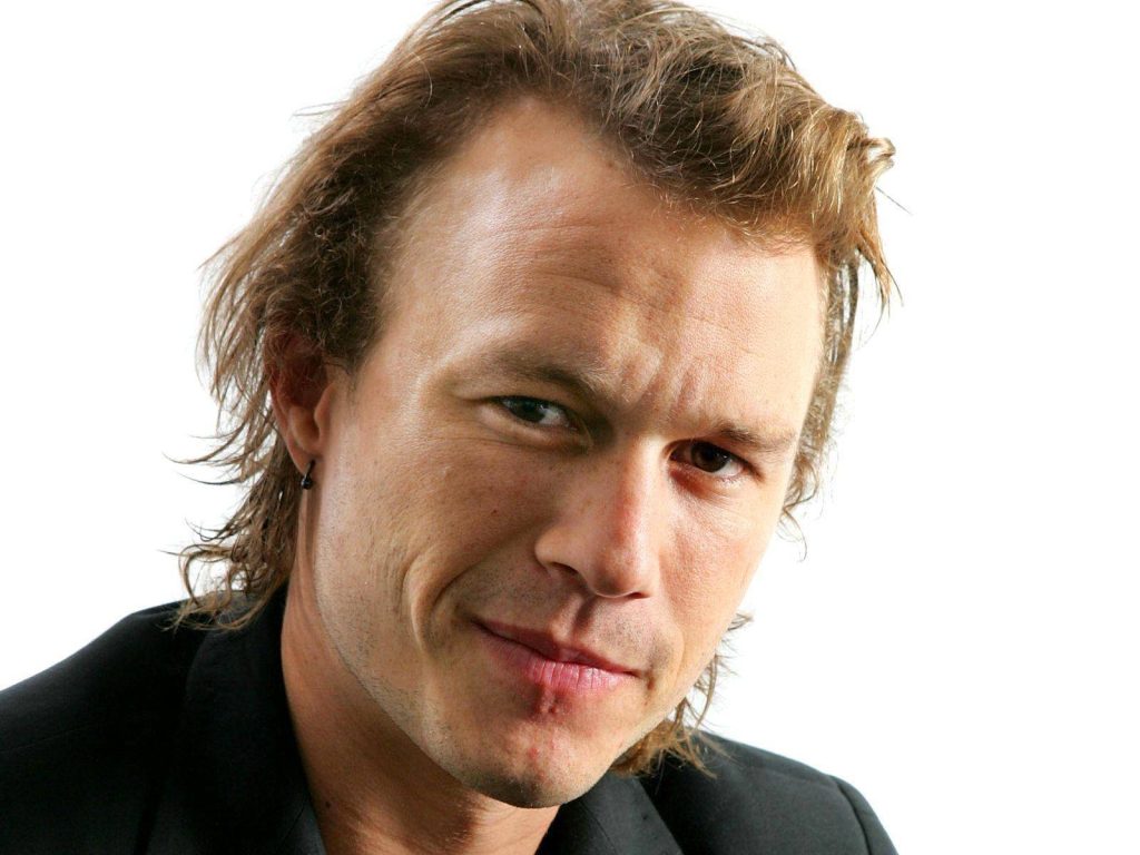 Close-up portrait of Heath Ledger with intense gaze natural light bright white background studio Wallpaper