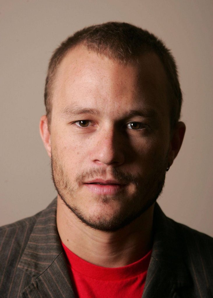 Heath Ledger close-up portrait with soft lighting in red shirt and pinstriped blazer wallpaper