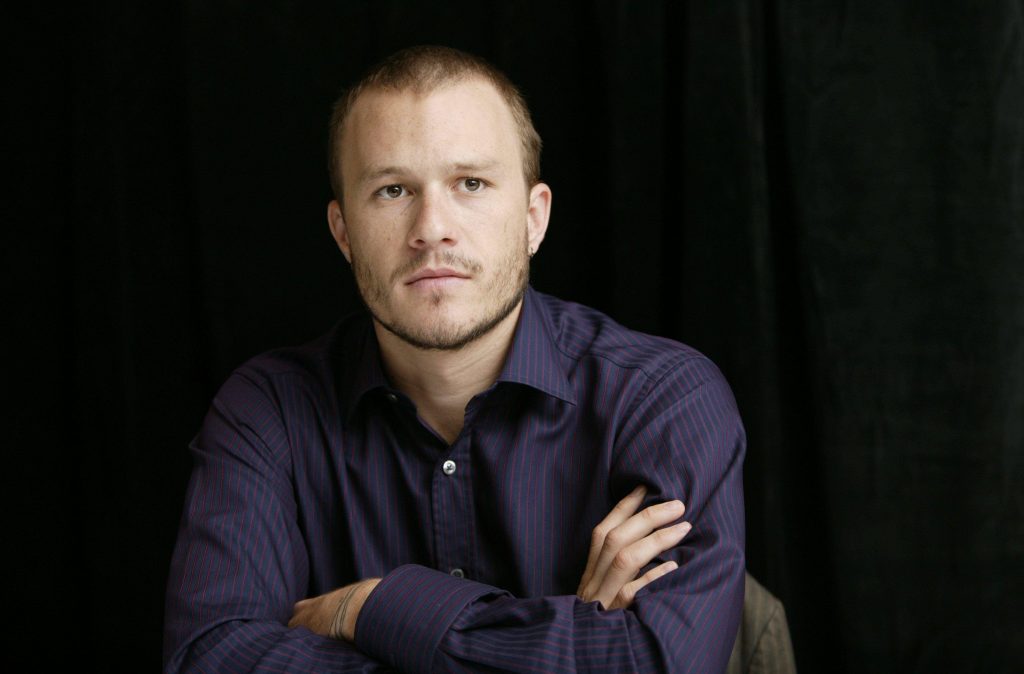 Heath Ledger portrait wearing dark pinstriped shirt arms crossed black background studio lighting Wallpaper