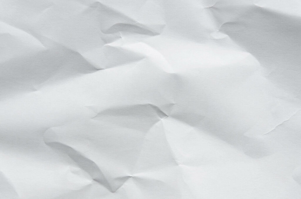 Minimalist white crumpled paper wallpaper with soft natural lighting and organic textured folds