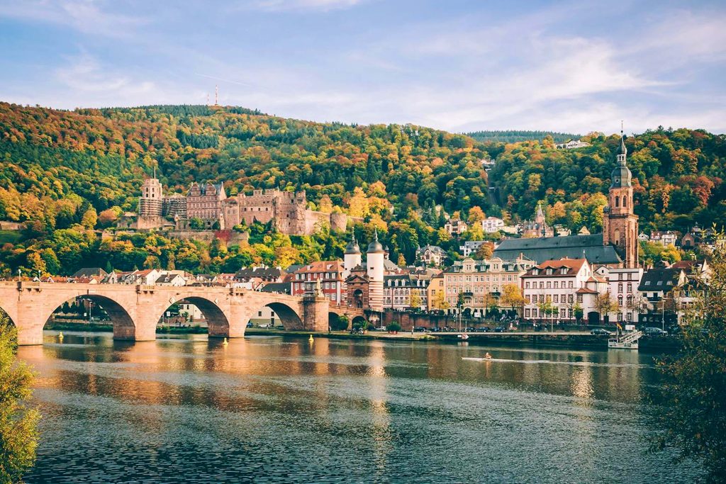 Heidelberg Castle and Old Bridge over Neckar River framed by colorful autumn foliage scenic view Wallpaper