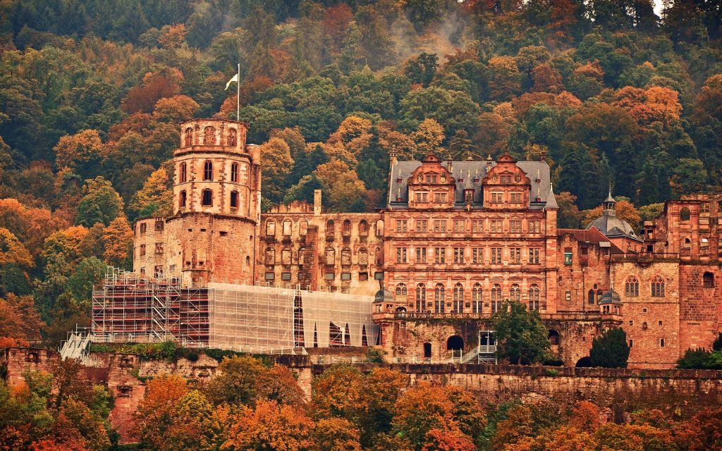 Heidelberg Castle in autumn with red sandstone and vibrant orange golden foliage wallpaper