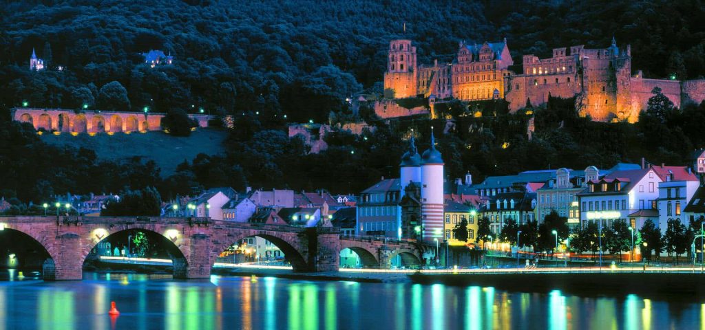 Heidelberg Castle and Old Bridge illuminated at night reflecting on Neckar River serene scene Wallpaper