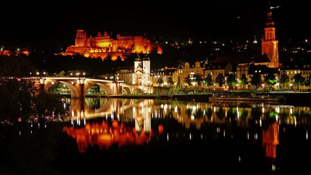 Night view of illuminated Heidelberg Castle and Old Bridge reflecting on Neckar River Germany wallpaper
