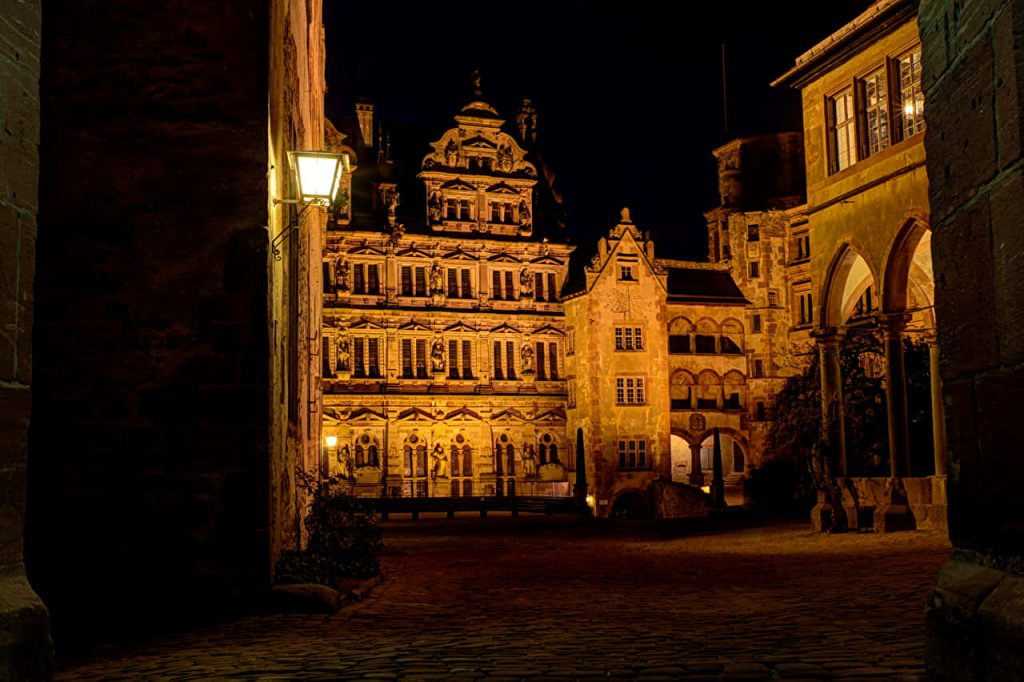 Heidelberg Castle Renaissance courtyard glowing golden at night historic German landmark wallpaper