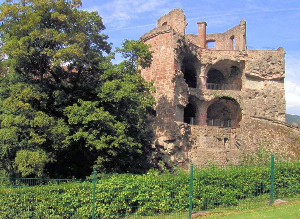 Heidelberg Castle red sandstone tower framed by green foliage historic German architecture wallpaper