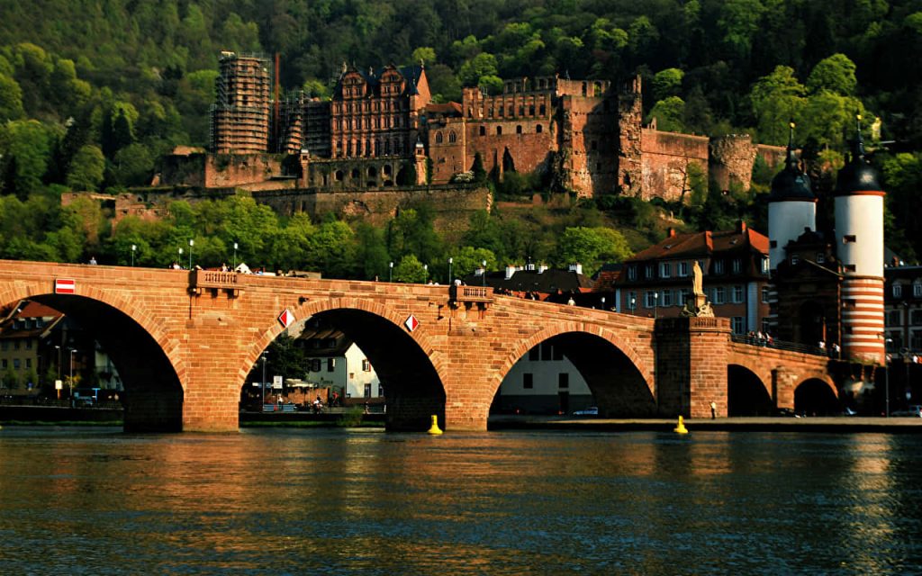 Heidelberg Old Bridge and Castle with red sandstone and Neckar River in scenic green hills Wallpaper