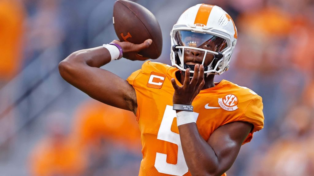 Tennessee Volunteers quarterback Hendon Hooker in orange jersey preparing pass stadium lighting Wallpaper