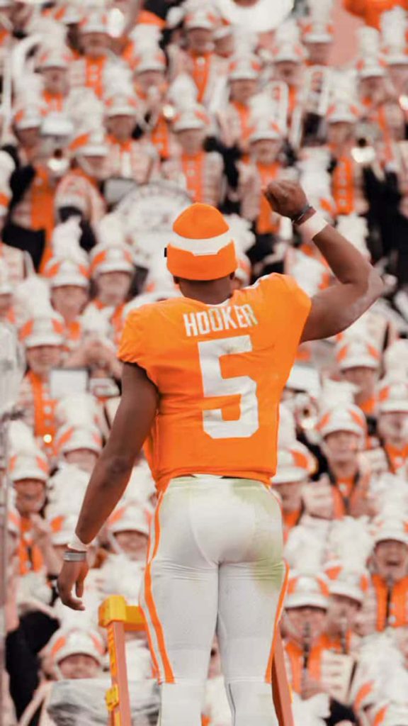 Quarterback Hendon Hooker in Tennessee Volunteers orange celebrates on ladder with crowd Wallpaper