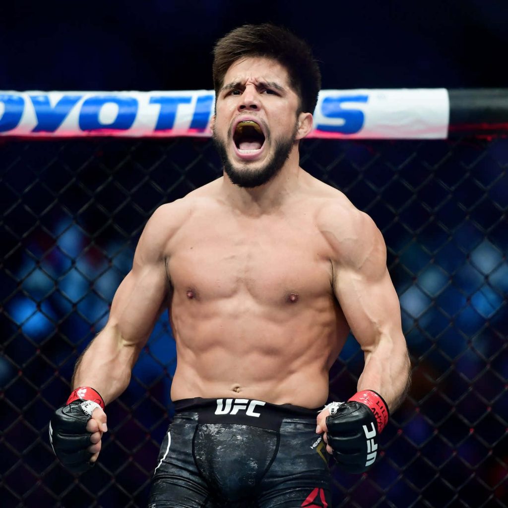 Henry Cejudo celebrates victory inside Octagon muscles flexed intense MMA sports wallpaper background