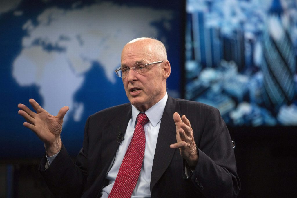 Henry M Paulson former US Treasury Secretary in suit speaking with financial data background Wallpaper