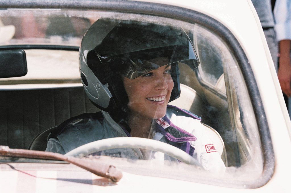 Lindsay Lohan in racing suit driving Herbie Volkswagen Beetle from Herbie Fully Loaded film wallpaper