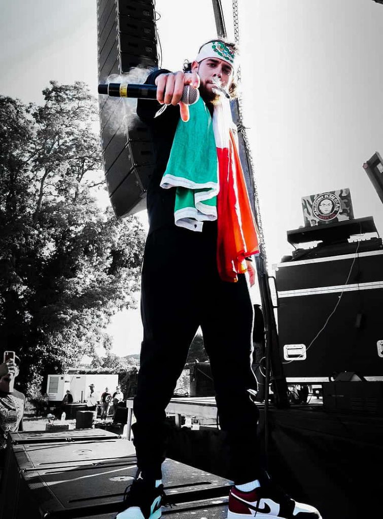 Herencia de Patrones live concert performer with Mexican flag high-contrast vibrant wallpaper