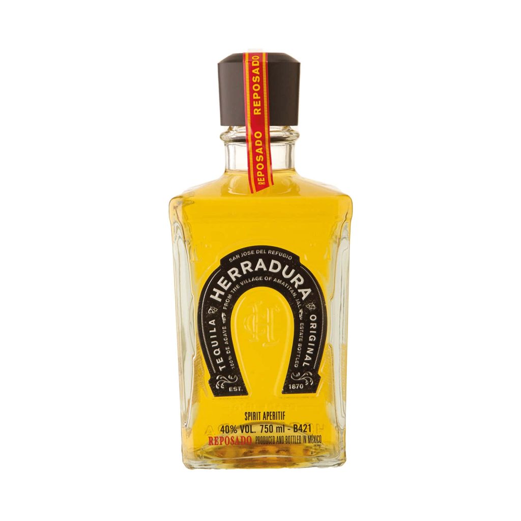 Herradura Reposado Tequila bottle with amber spirit on white background studio photo wallpaper