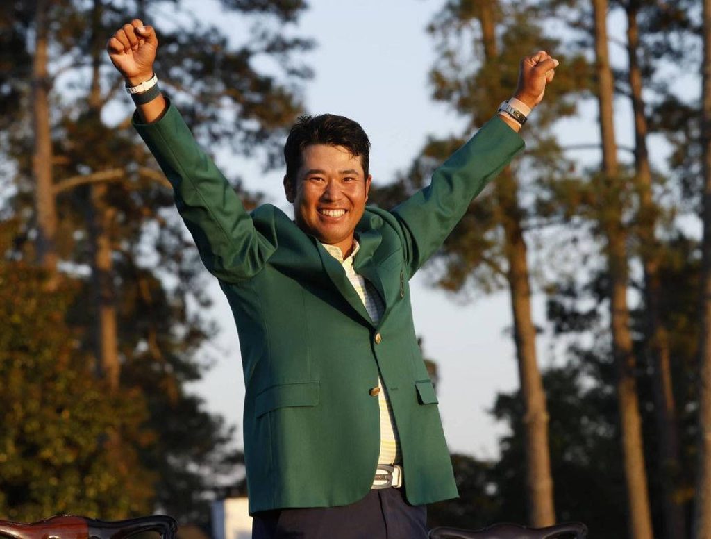Hideki Matsuyama celebrating Masters win in green jacket with forest background wallpaper