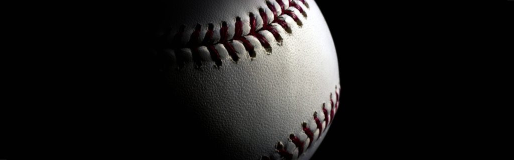 High contrast macro shot of white baseball with red stitching on black minimalist background wallpaper