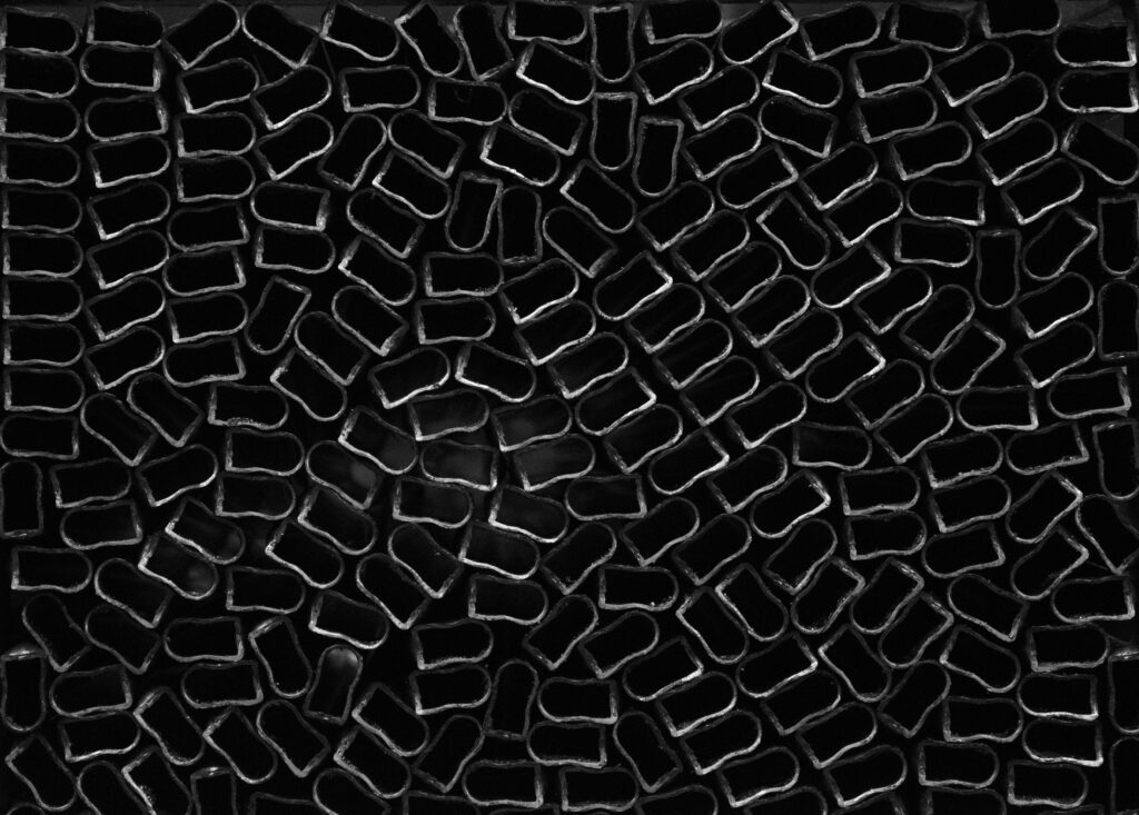 Cut Black Metal Tubes Wallpaper: Industrial Aesthetic Background