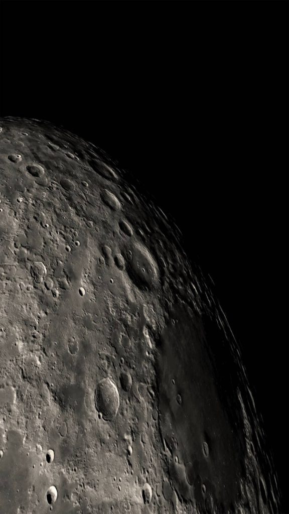 High contrast detailed lunar surface wallpaper with craters and shadows on deep black space background