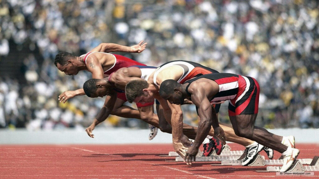 High-Def Wallpaper of Sprinters Launching at Track & Field Race