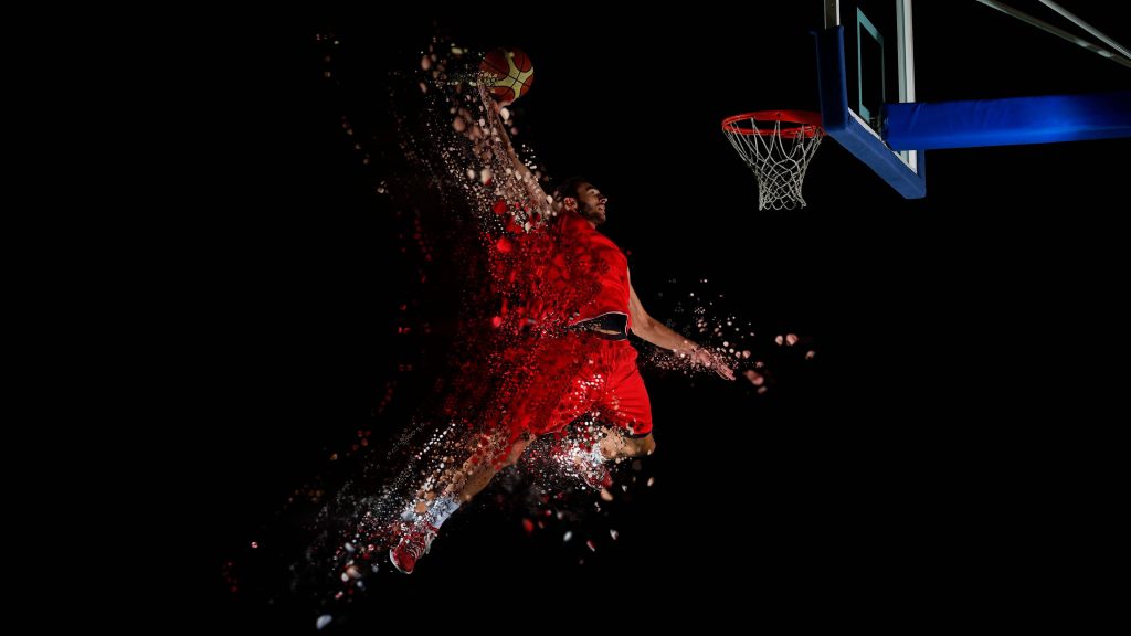 Basketball player in red uniform dunking with particle effects on black digital background wallpaper