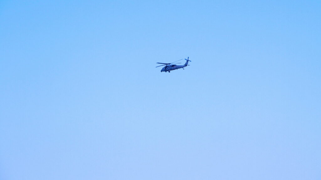 Helicopter flying high in clear blue sky symbolizing adventure freedom and open space Wallpaper