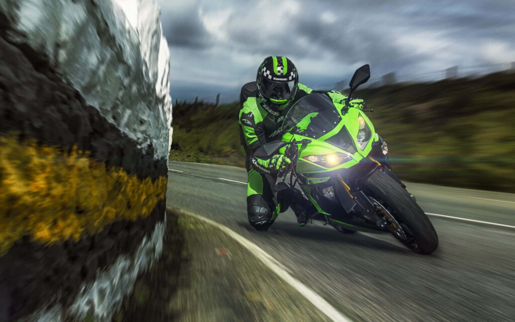 Adrenaline-Fueled Kawasaki Motorcycle Wallpaper on Scenic Road