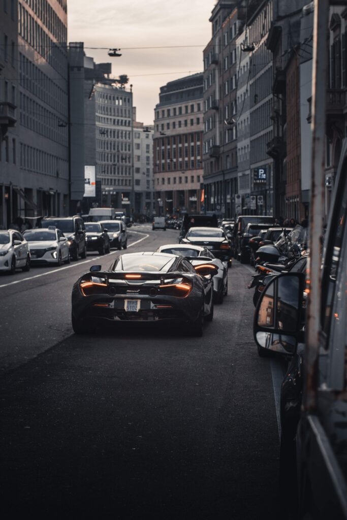 High-Performance Car Driving Through Bustling City at Night Wallpaper
