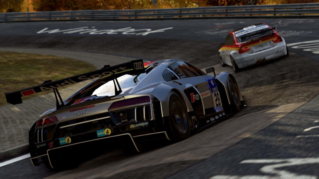 Two high-performance race cars racing on winding hill racetrack with autumn trees background Wallpaper